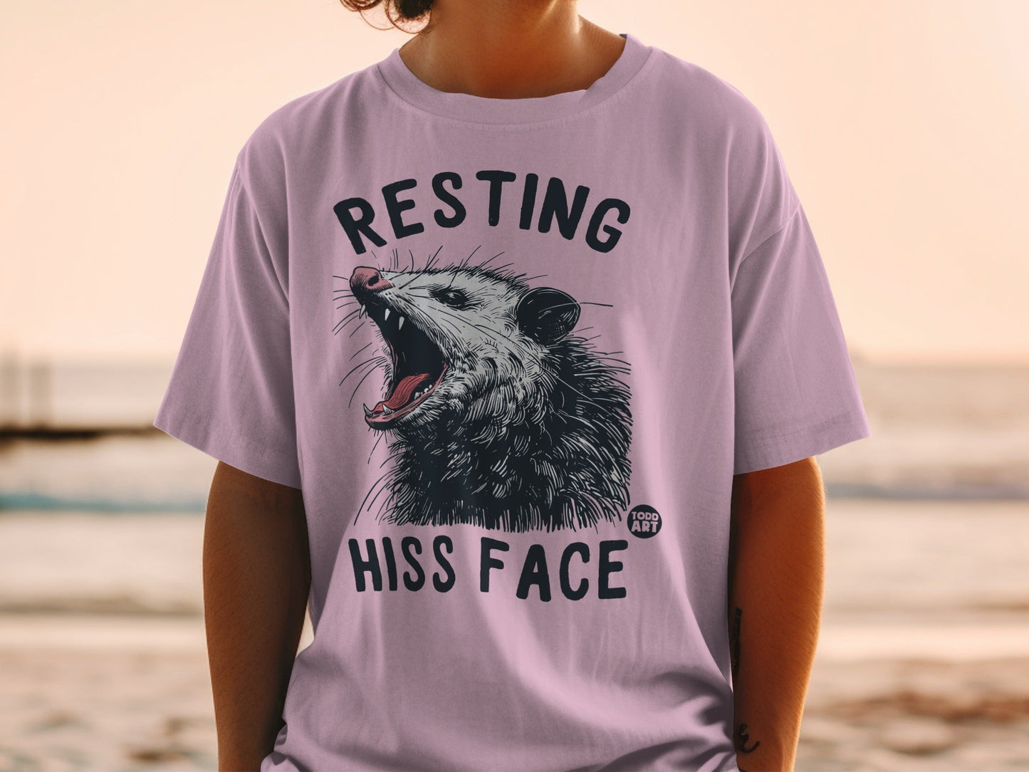 Opossum yawning on a purple t-shirt with text "RESTING HISS FACE".
