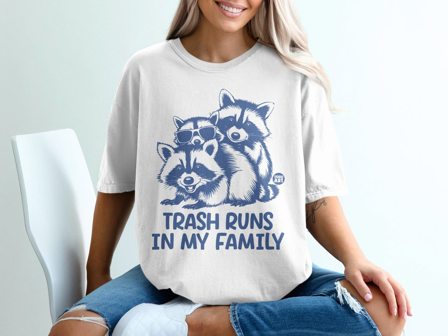 T-shirt with two raccoons wearing sunglasses, text "TRASH RUNS IN MY FAMILY".