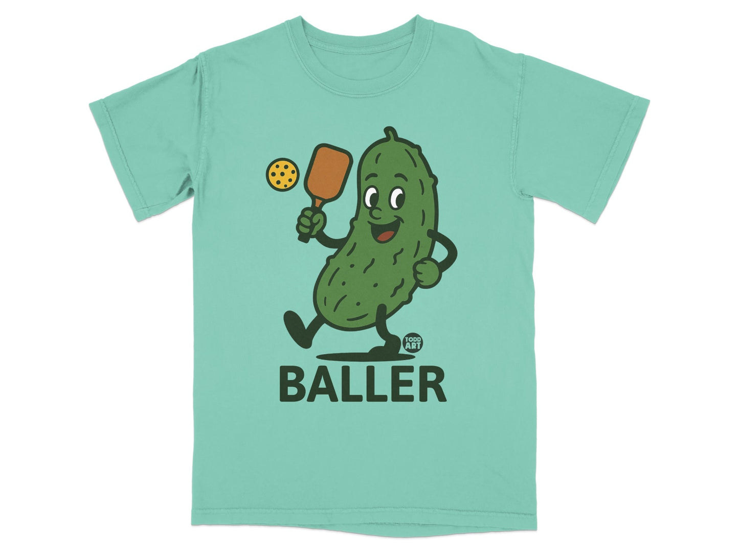 Teal t-shirt with cartoon pickle playing pickleball, reads "FOOD ART BALLER".