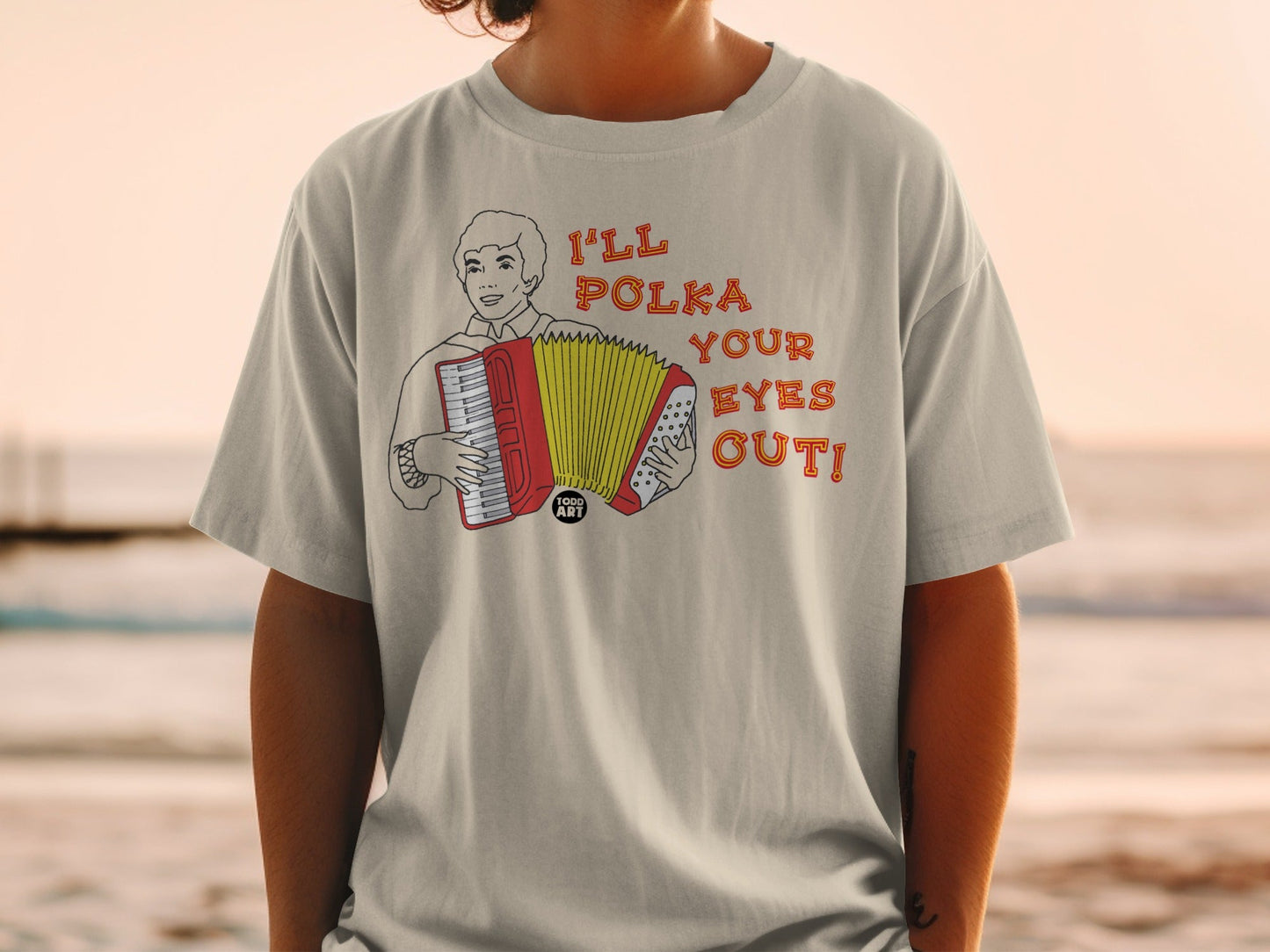 T-shirt with a drawing of a man playing an accordion and the text "I'LL POLKA YOUR EYES OUT!"