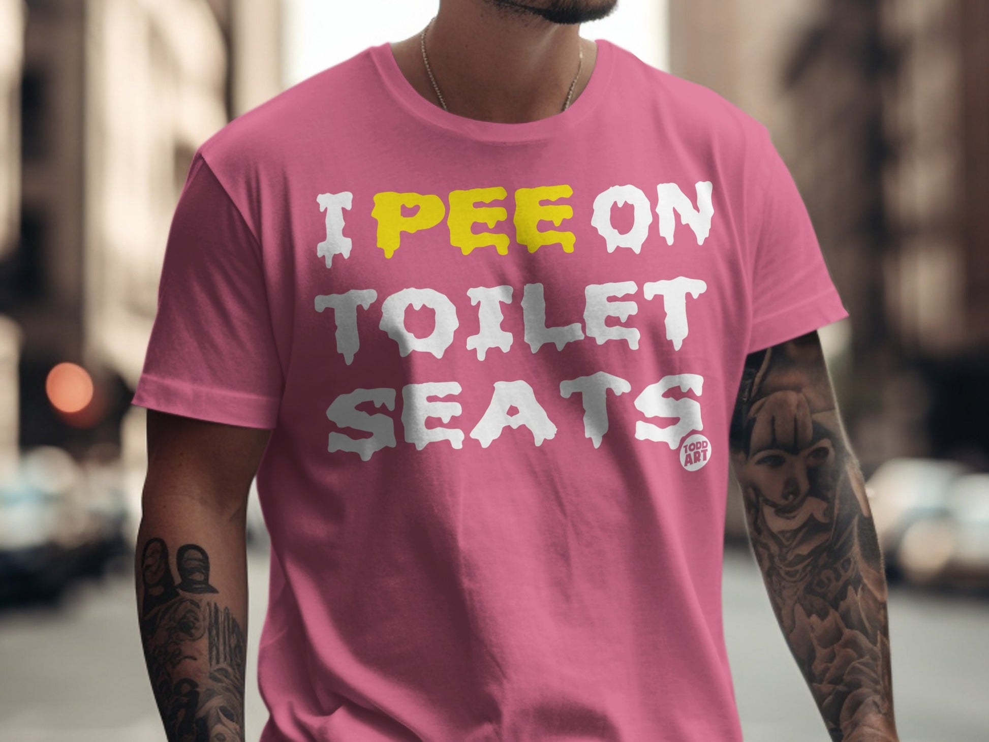Pink t-shirt with yellow and white text reading "I PEE ON TOILET SEATS".