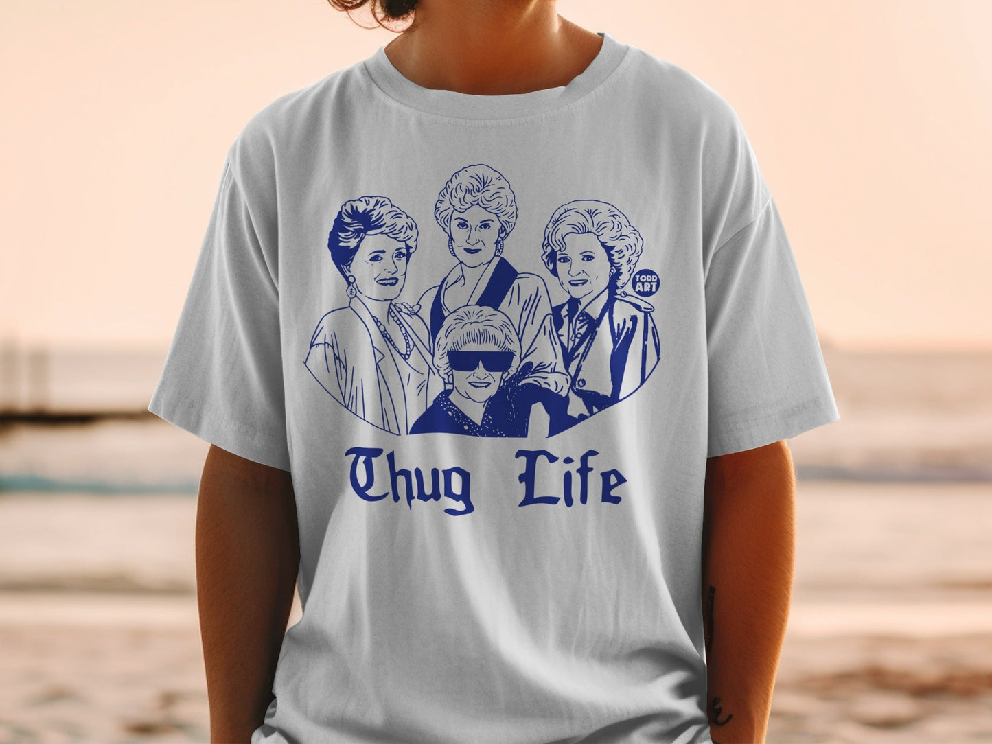 White t-shirt with blue graphic of Golden Girls characters and "Thug Life" text.