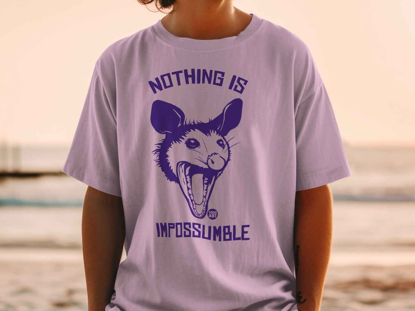 Purple t-shirt with a screaming opossum and "Nothing is Impossible" text.