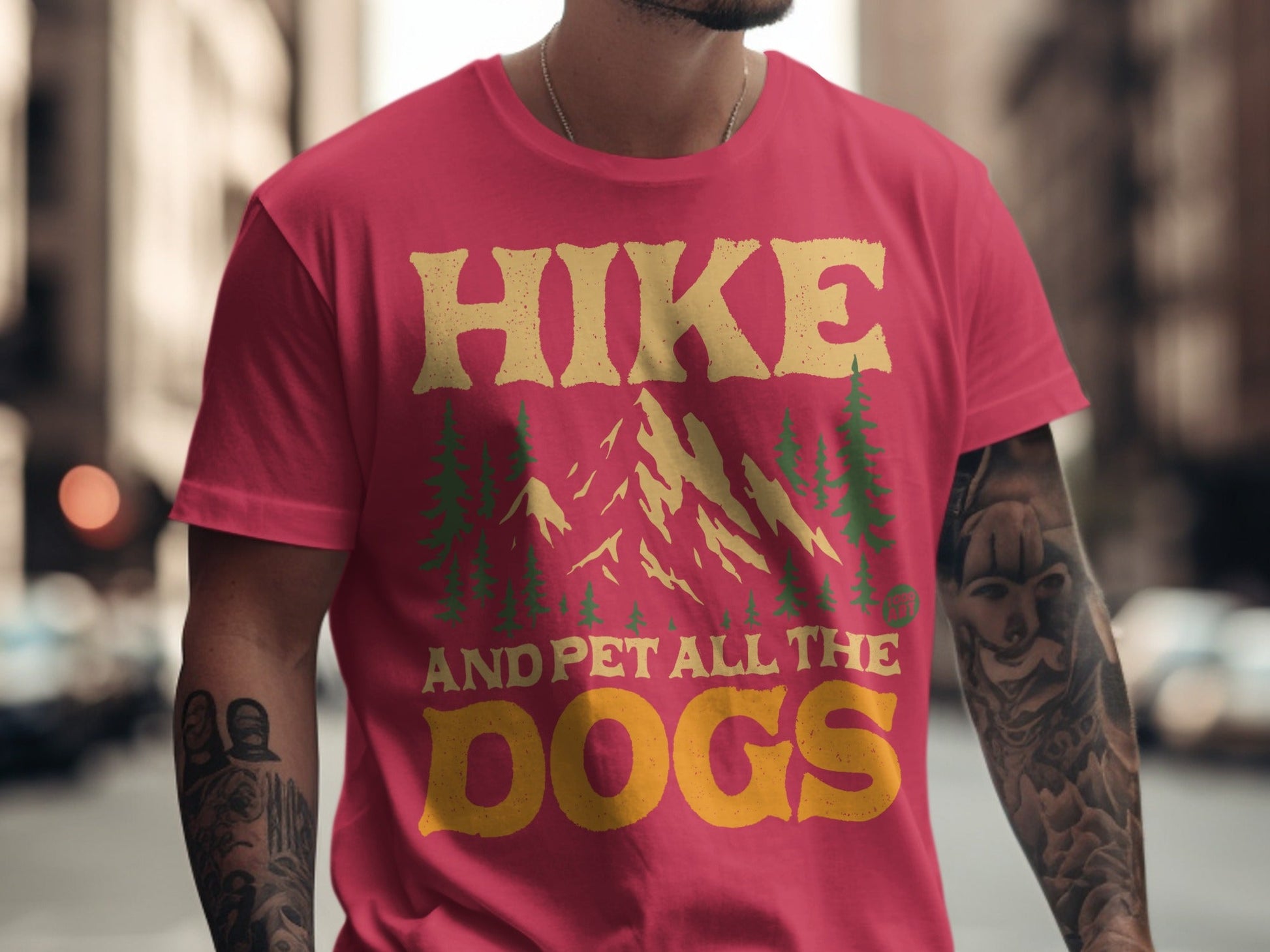 Red t-shirt with "HIKE AND PET ALL THE DOGS" text and mountain graphic.