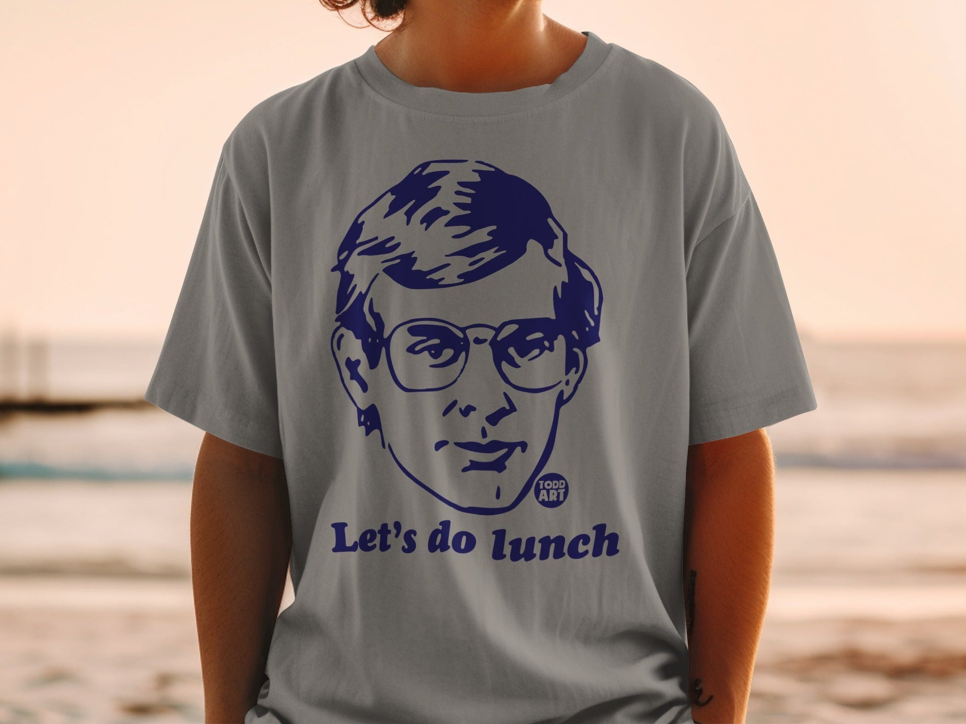 Grey t-shirt with a blue graphic of a man's face and "Let's do lunch" text.