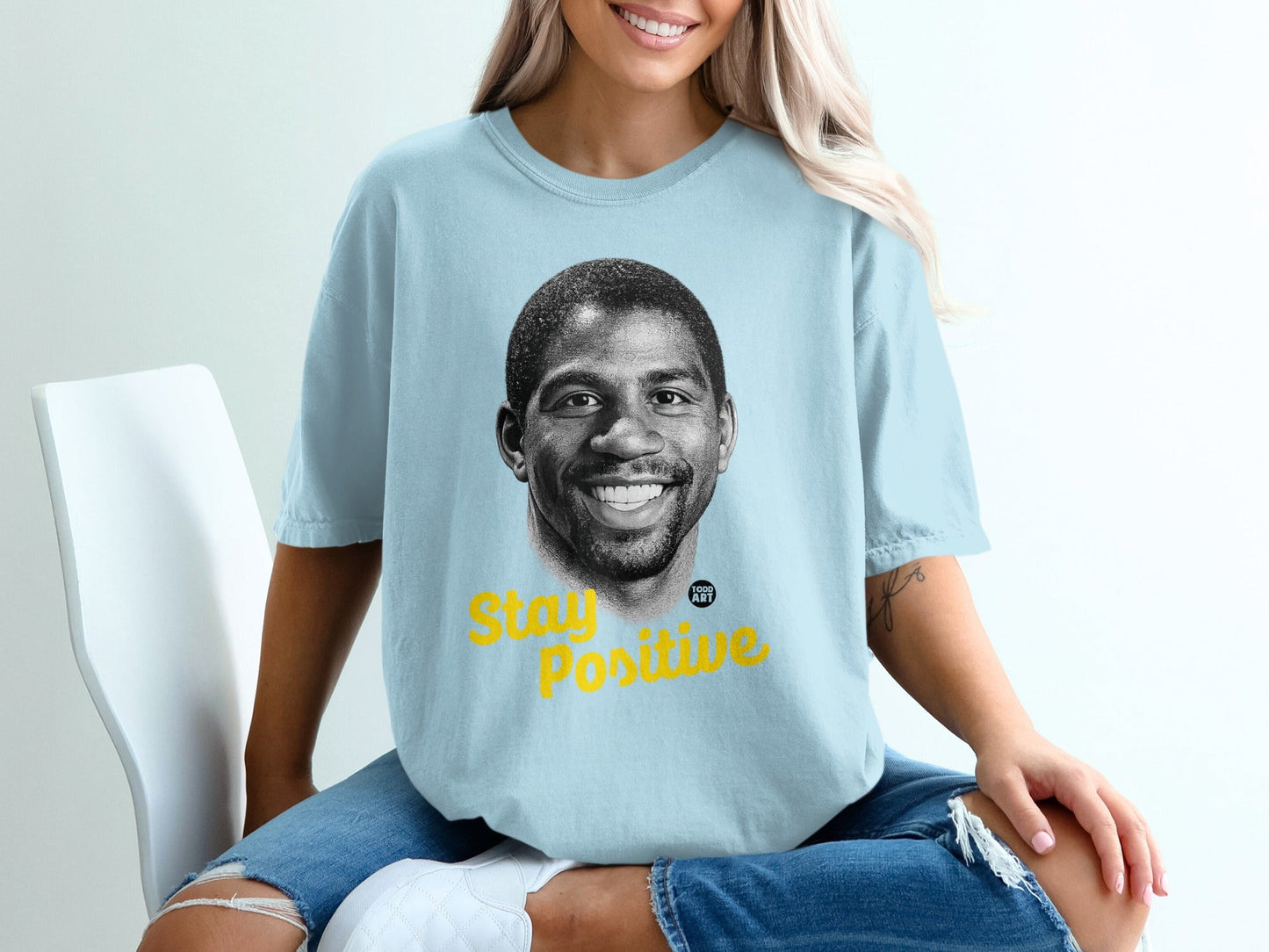 Light blue t-shirt with Magic Johnson's portrait and "Stay Positive" text.