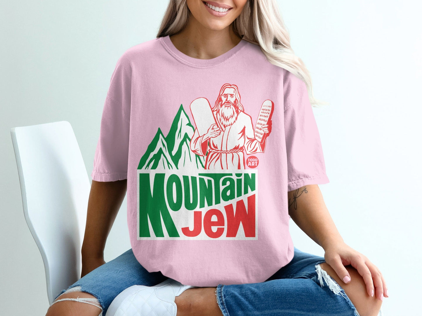 Pink t-shirt with "Mountain Jew" text and biblical imagery.
