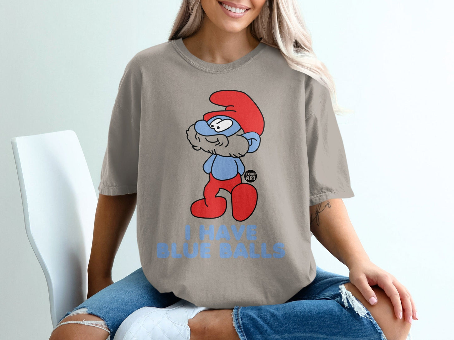 Smurf character in red hat on t-shirt with blue text "I HAVE BLUE BALLS".