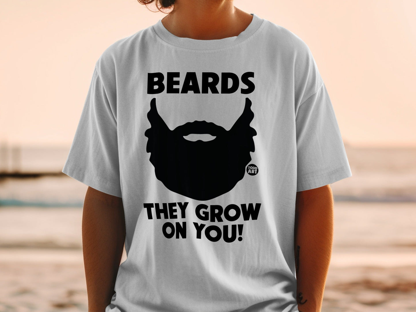 Black beard graphic with "BEARDS THEY GROW ON YOU!" text on white t-shirt.