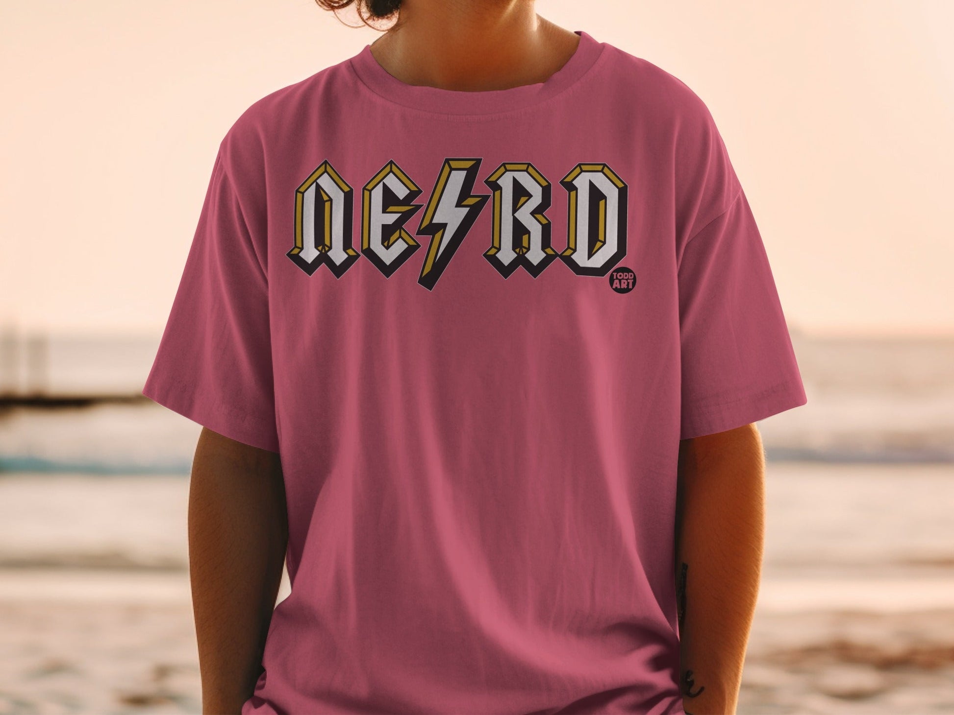 Pink t-shirt with "NERD" in yellow and white lightning bolt font.