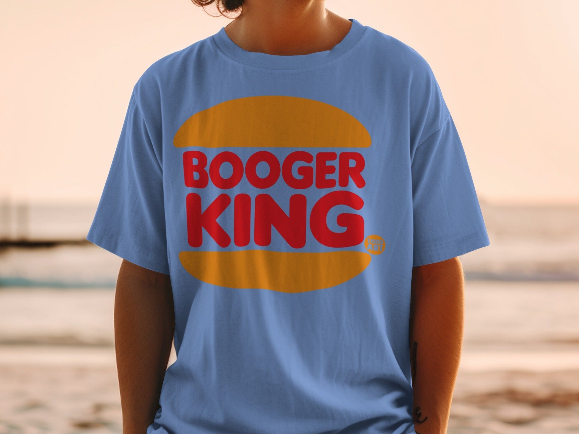 Blue t-shirt with Booger King logo on chest, worn by person.