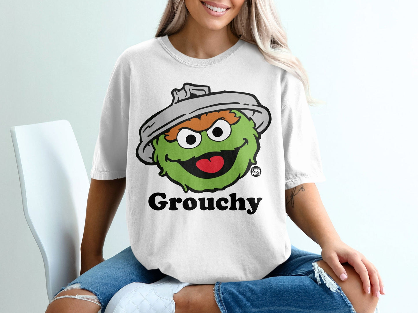 White t-shirt with Oscar the Grouch from Sesame Street and the word "Grouchy".