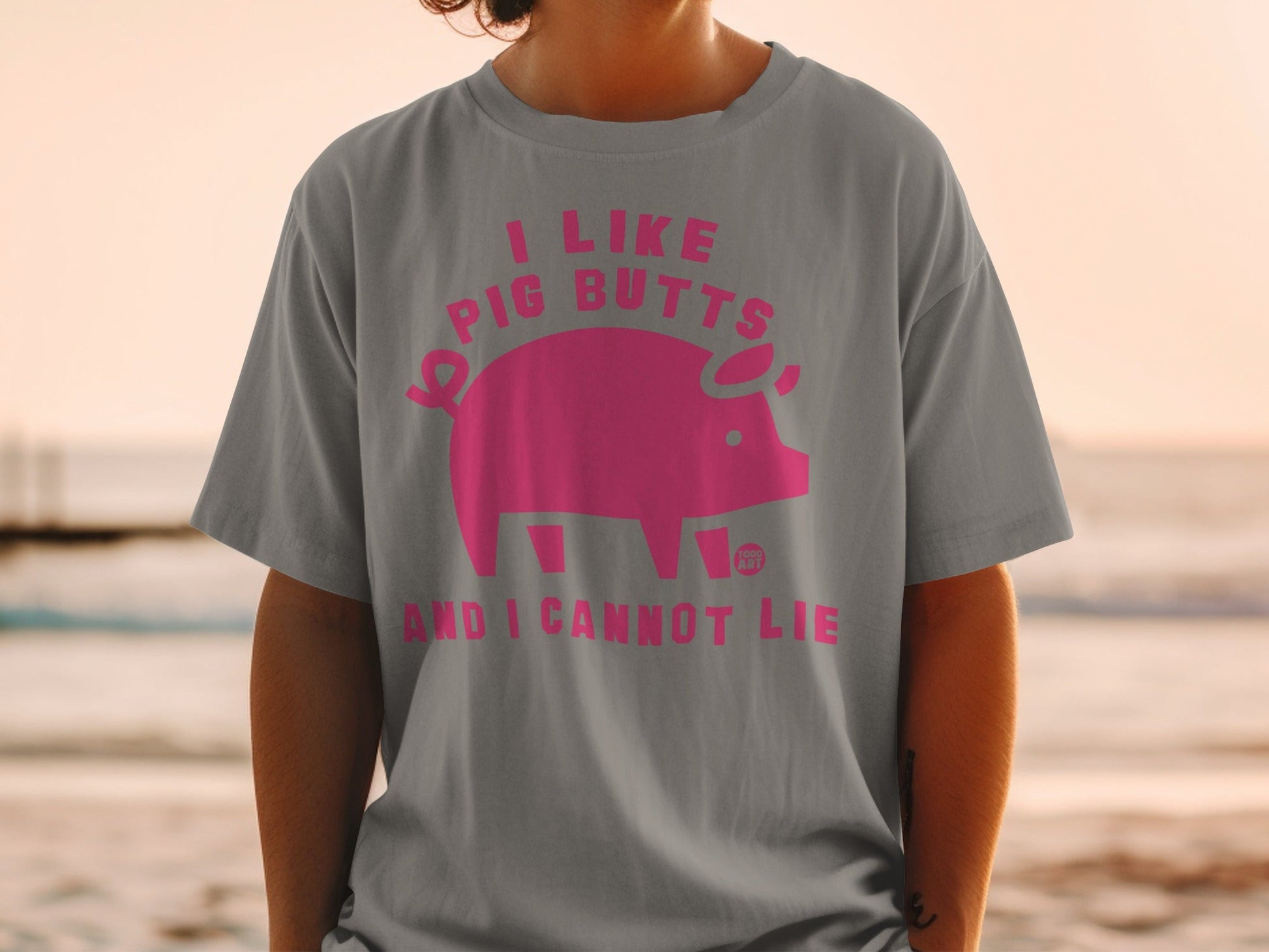 Grey t-shirt with pink text and pig graphic: "I like pig butts and I cannot lie".