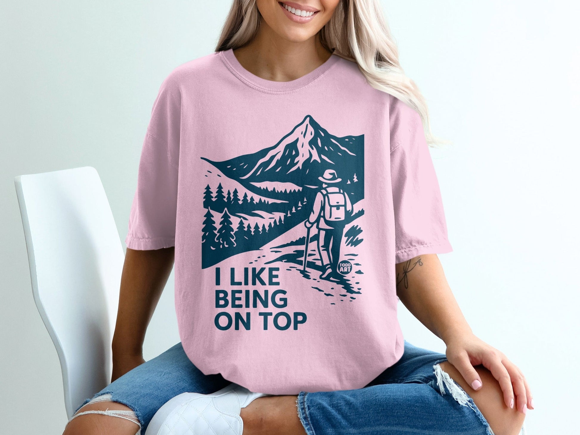 Pink t-shirt with "I LIKE BEING ON TOP" and mountain hiker graphic.