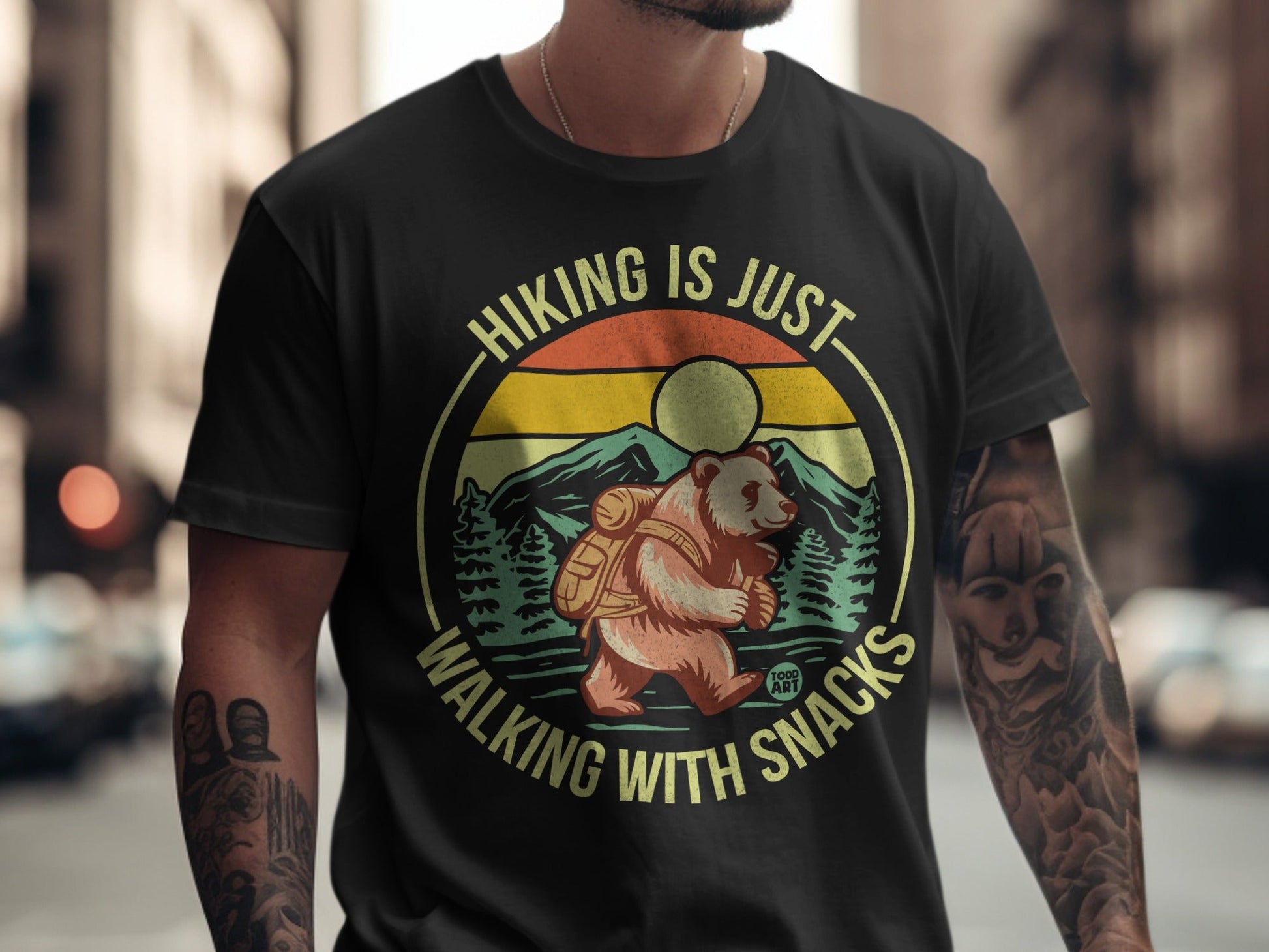 Bear with backpack hiking with snacks text, circular design with mountains and sun.