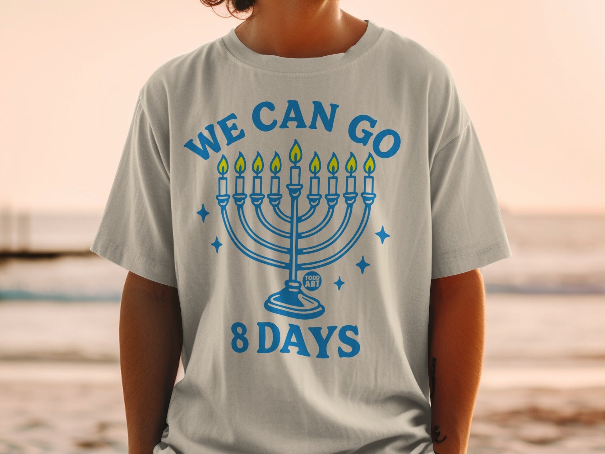 Blue t-shirt with menorah graphic and "WE CAN GO 8 DAYS" text.