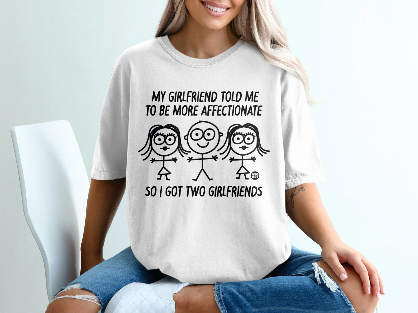 White t-shirt with "My girlfriend told me to be more affectionate so I got two girlfriends" text and stick figures.