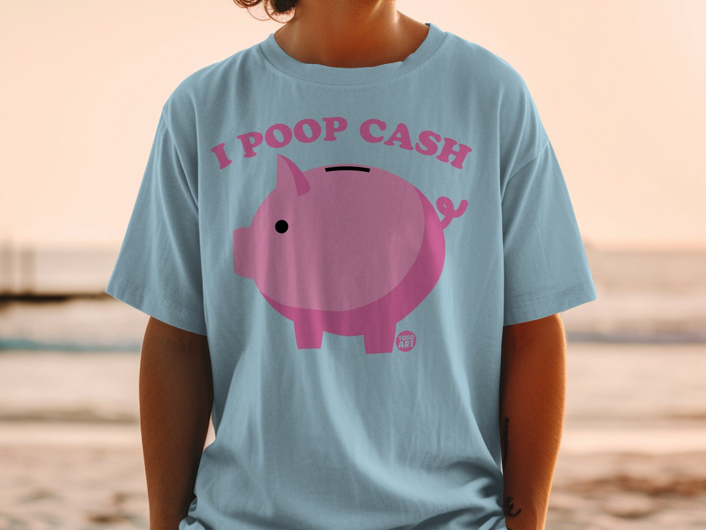 Light blue t-shirt with "I POOP CASH" and pink piggy bank graphic.