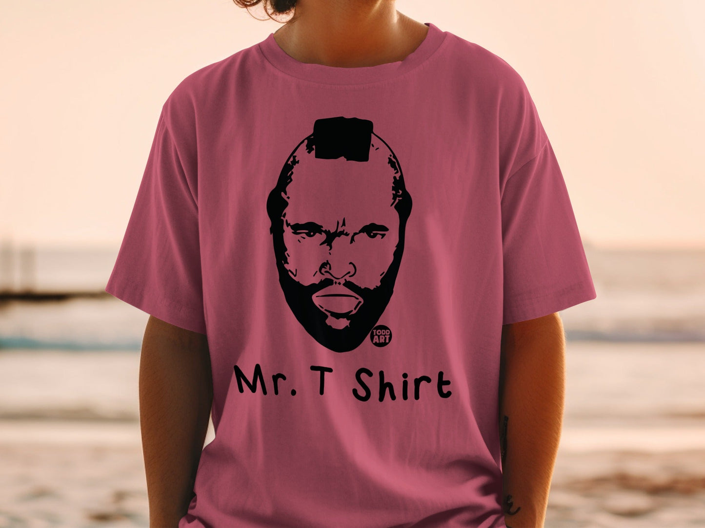 Pink t-shirt with black illustration of Mr. T's face and "MR. T SHIRT" text.