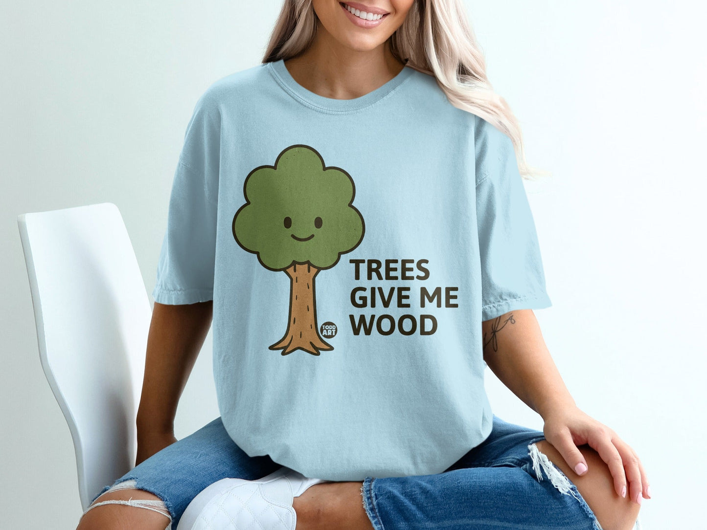 Light blue t-shirt with cartoon tree and text "TREES GIVE ME WOOD".