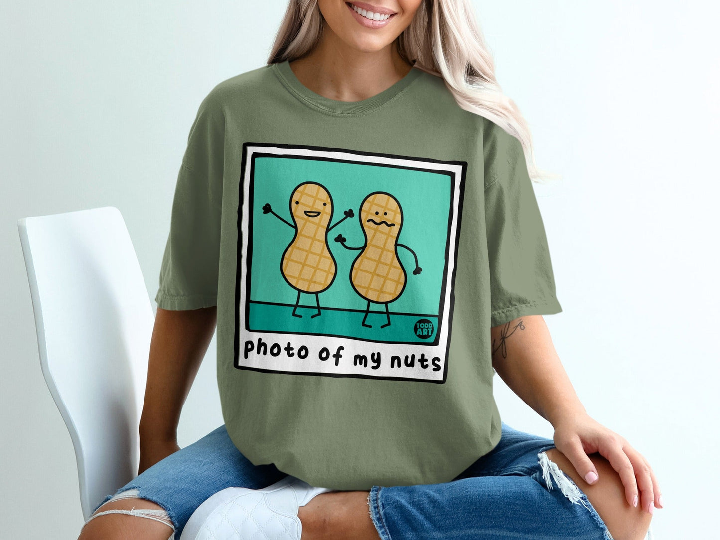 Olive green t-shirt with cartoon peanuts saying "photo of my nuts".