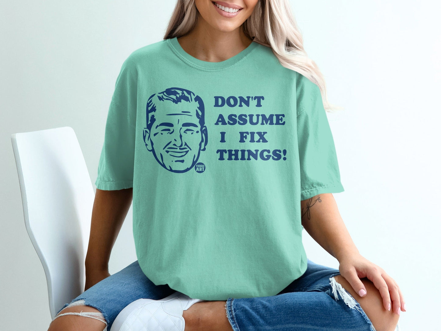 Teal t-shirt with "DON'T ASSUME I FIX THINGS!" and a cartoon man.