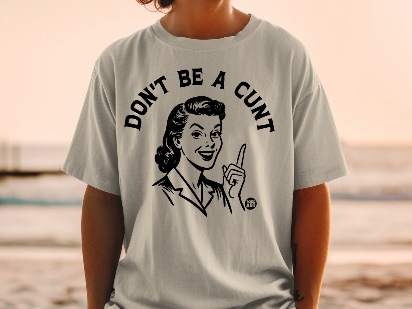 Grey t-shirt with graphic of woman pointing finger and text "DON'T BE A CUNT".