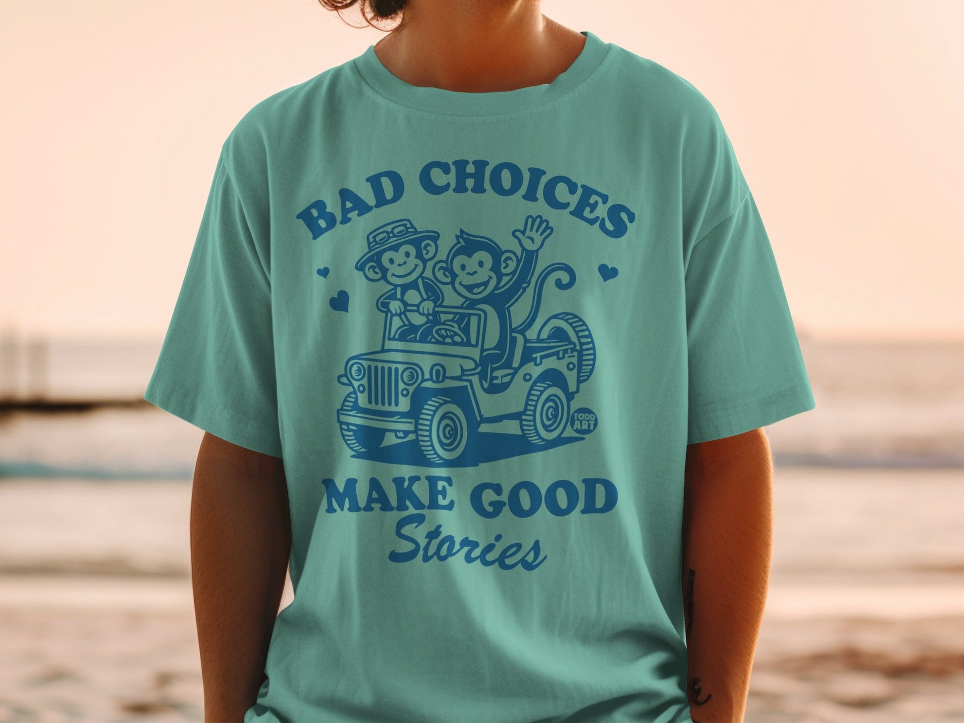 Teal t-shirt with "BAD CHOICES MAKE GOOD STORIES" and monkeys in a jeep.