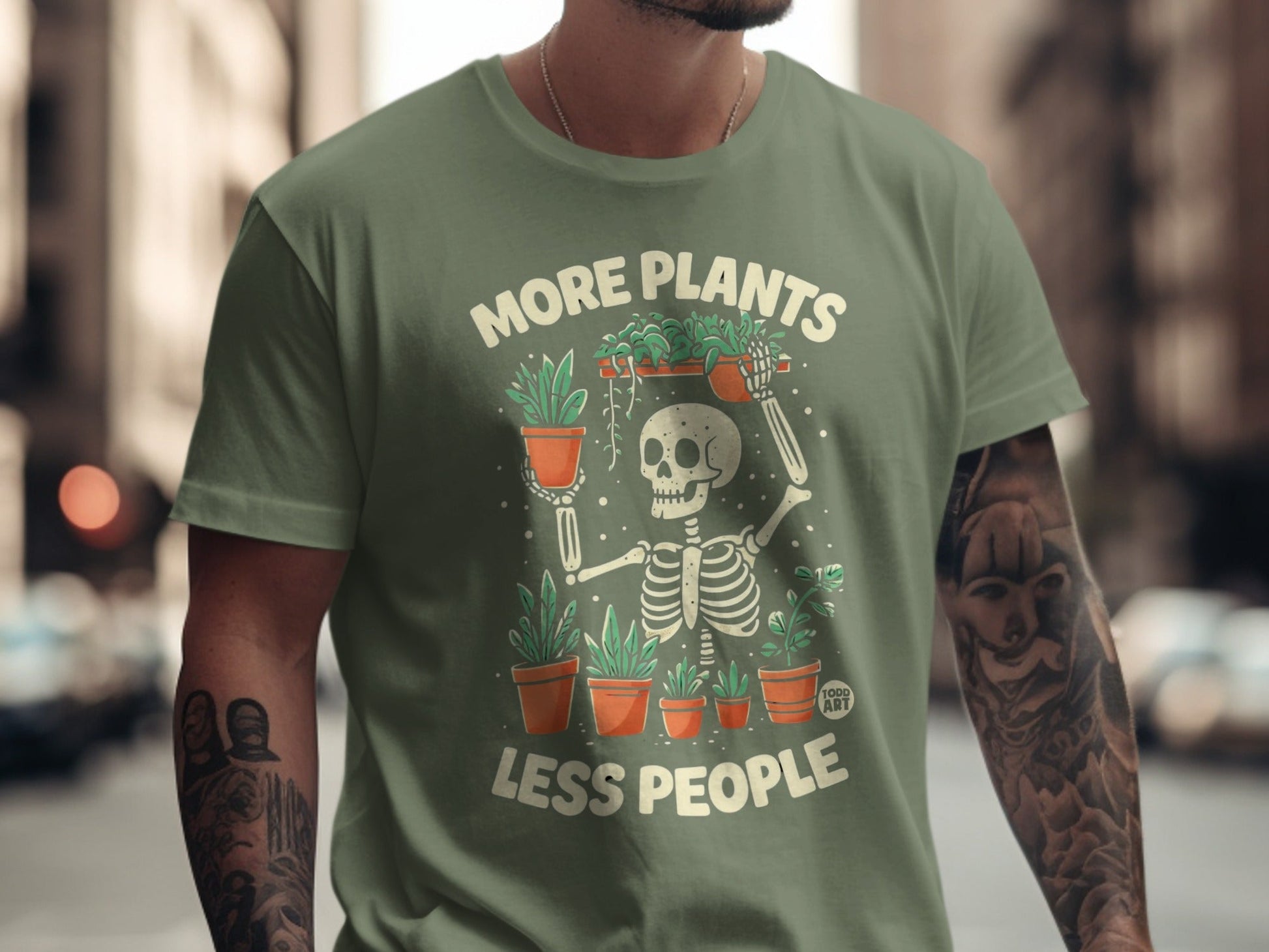 Green t-shirt with skeleton holding plants and text "More Plants Less People".