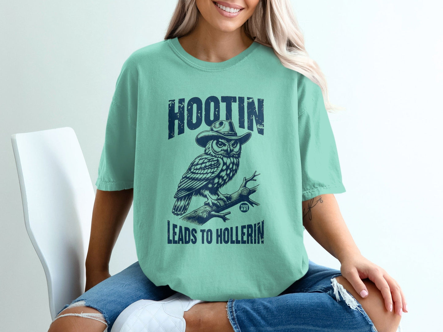 Teal t-shirt with owl in hat and text "HOOTIN LEADS TO HOLLERIN'".