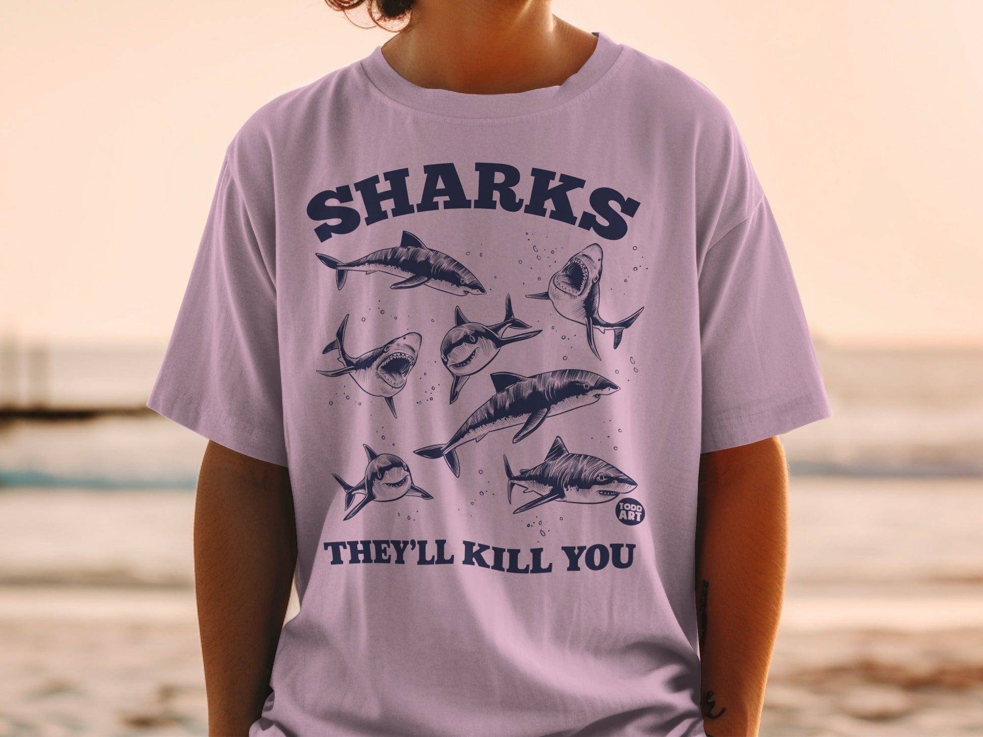 Purple t-shirt with cartoon sharks and "SHARKS THEY'LL KILL YOU" text.