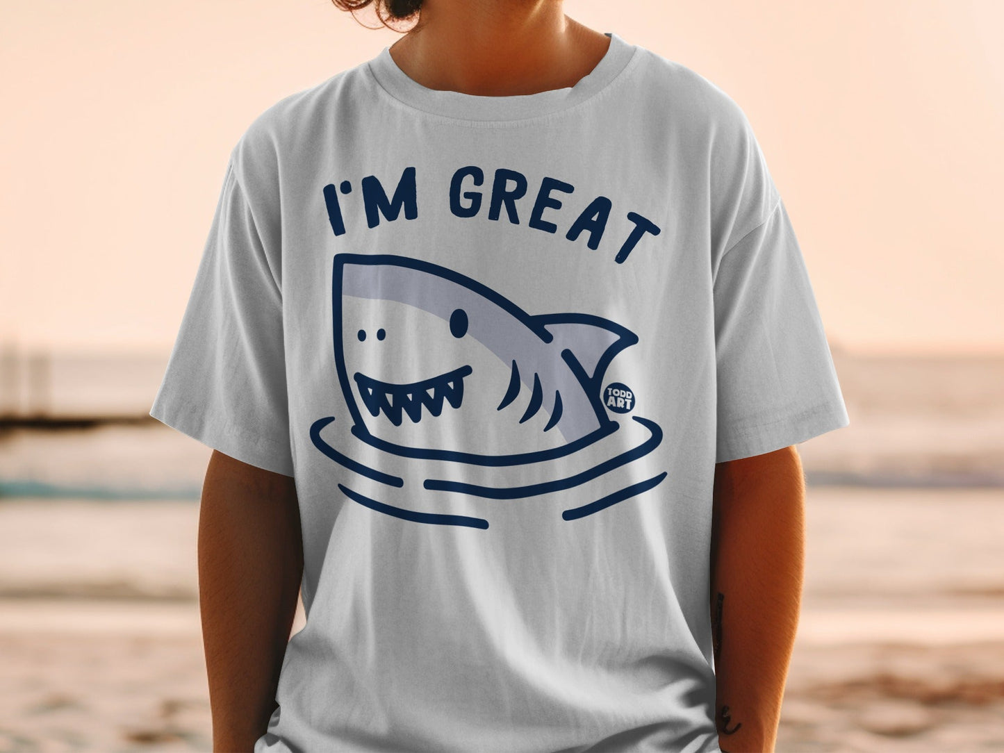 White t-shirt with a cartoon shark in water and "I'M GREAT" text.