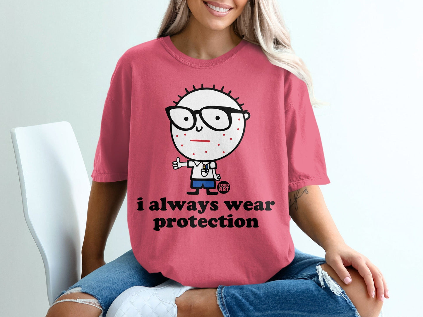 Pink t-shirt with cartoon character and "I always wear protection" text.