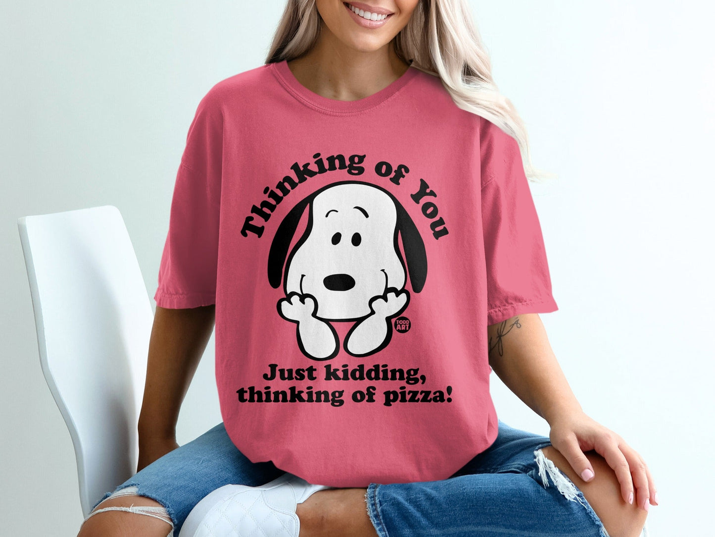 Pink t-shirt with Snoopy saying "Thinking of you. Just kidding, thinking of pizza!"