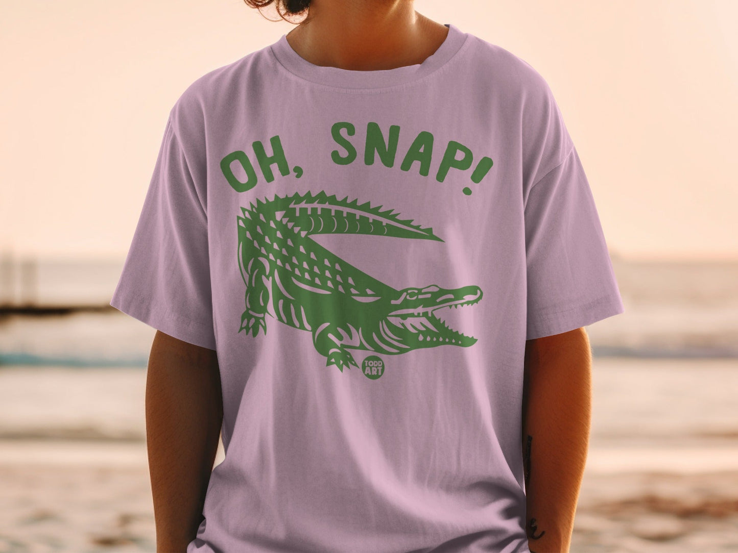Lavender t-shirt with a green alligator and "OH, SNAP!" text.