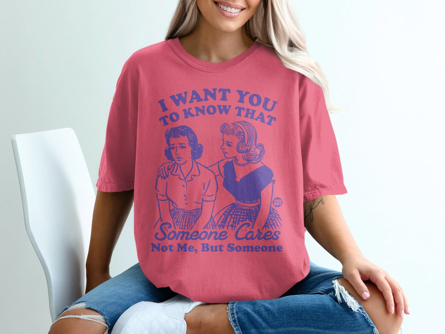 Pink t-shirt with blue text reading "I want you to know that someone cares. Not me, but someone."