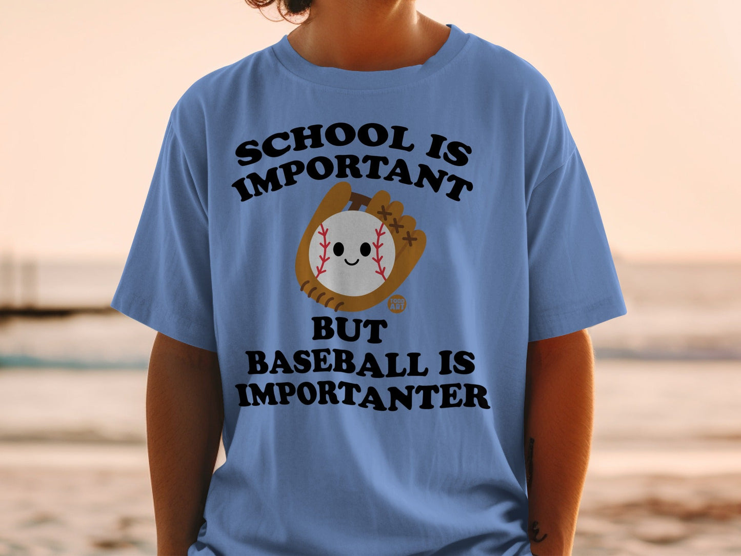 Blue t-shirt with text "SCHOOL IS IMPORTANT BUT BASEBALL IS IMPORTANTER" and cartoon baseball.