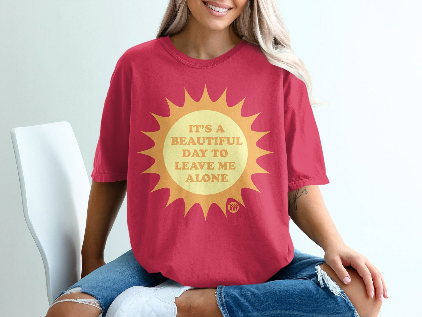 Red t-shirt with "It's a beautiful day to leave me alone" text on a sun graphic.