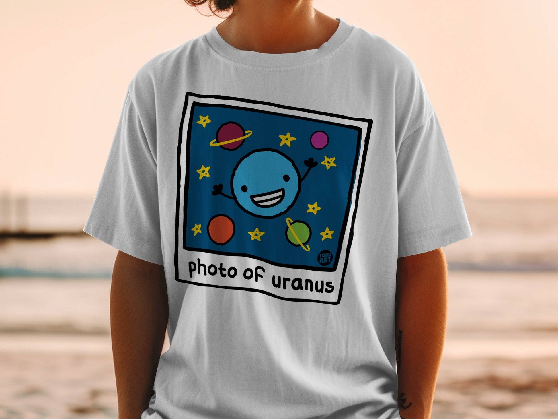 T-shirt with cartoon smiling blue planet Uranus and stars.