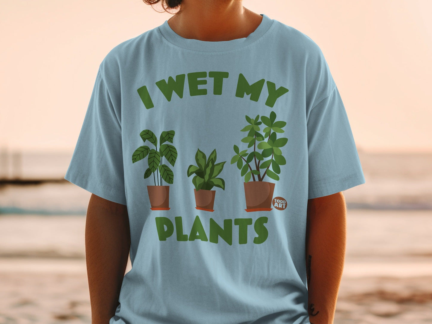 Light blue t-shirt with "I wet my plants" and three potted plants graphic.