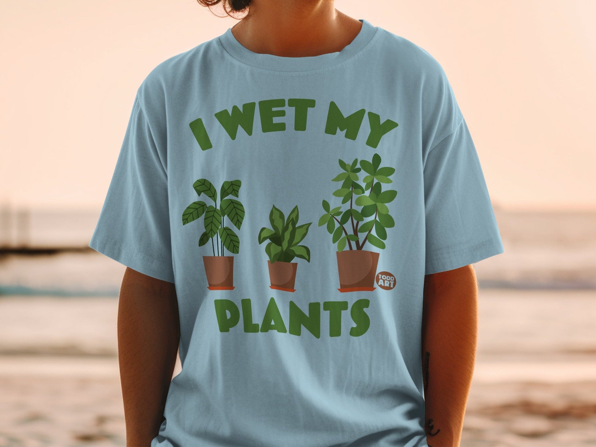 Light blue t-shirt with "I wet my plants" and three potted plants graphic.