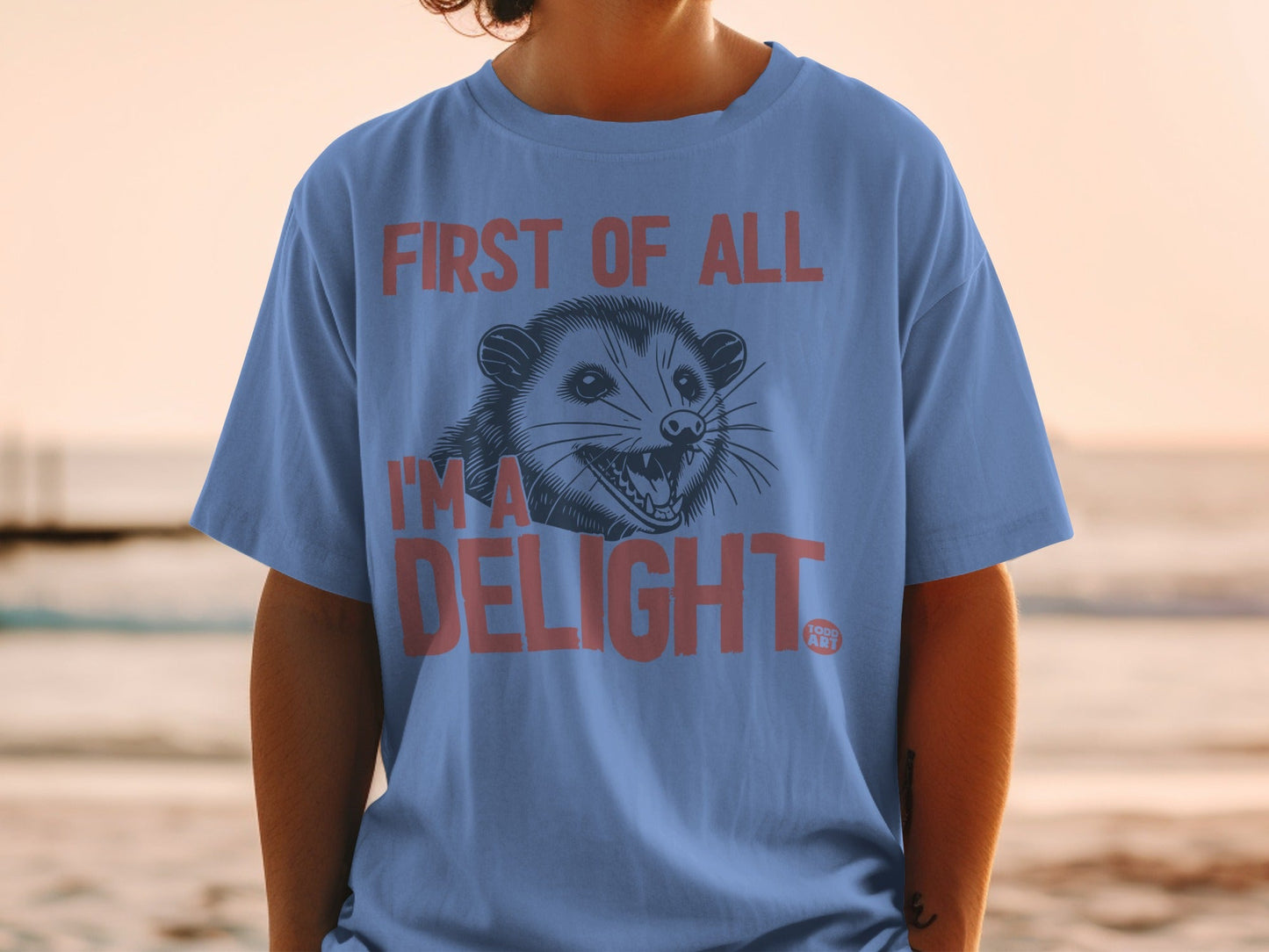 Blue t-shirt with "First of all I'm a delight" and possum graphic.