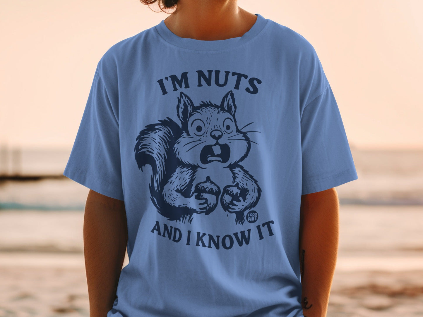 Blue t-shirt with surprised cartoon squirrel holding nuts, saying "I'm nuts and I know it".