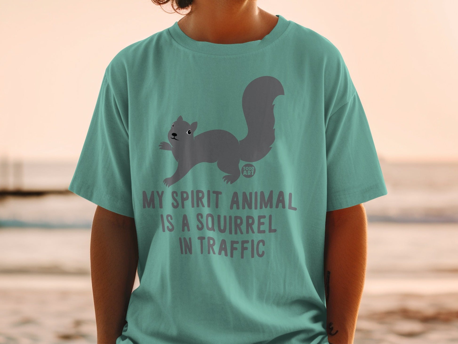 Teal t-shirt with a grey squirrel graphic and "My spirit animal is a squirrel in traffic" text.