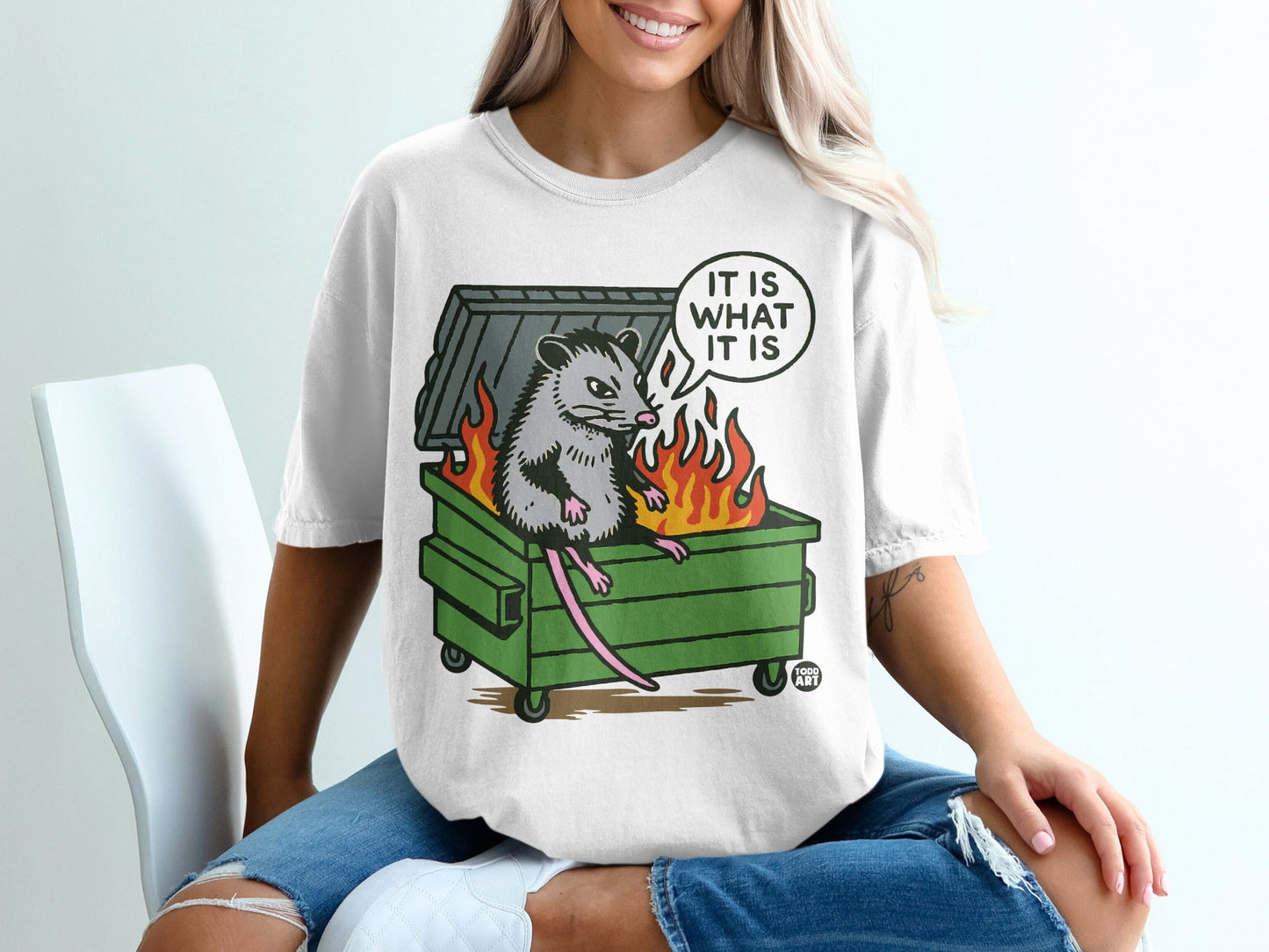 Opossum in a burning dumpster with "IT IS WHAT IT IS" text.
