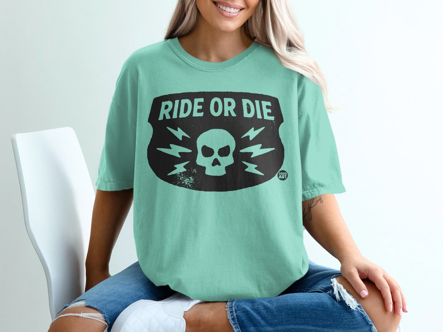 Green t-shirt with black "RIDE OR DIE" skull and lightning bolt graphic.