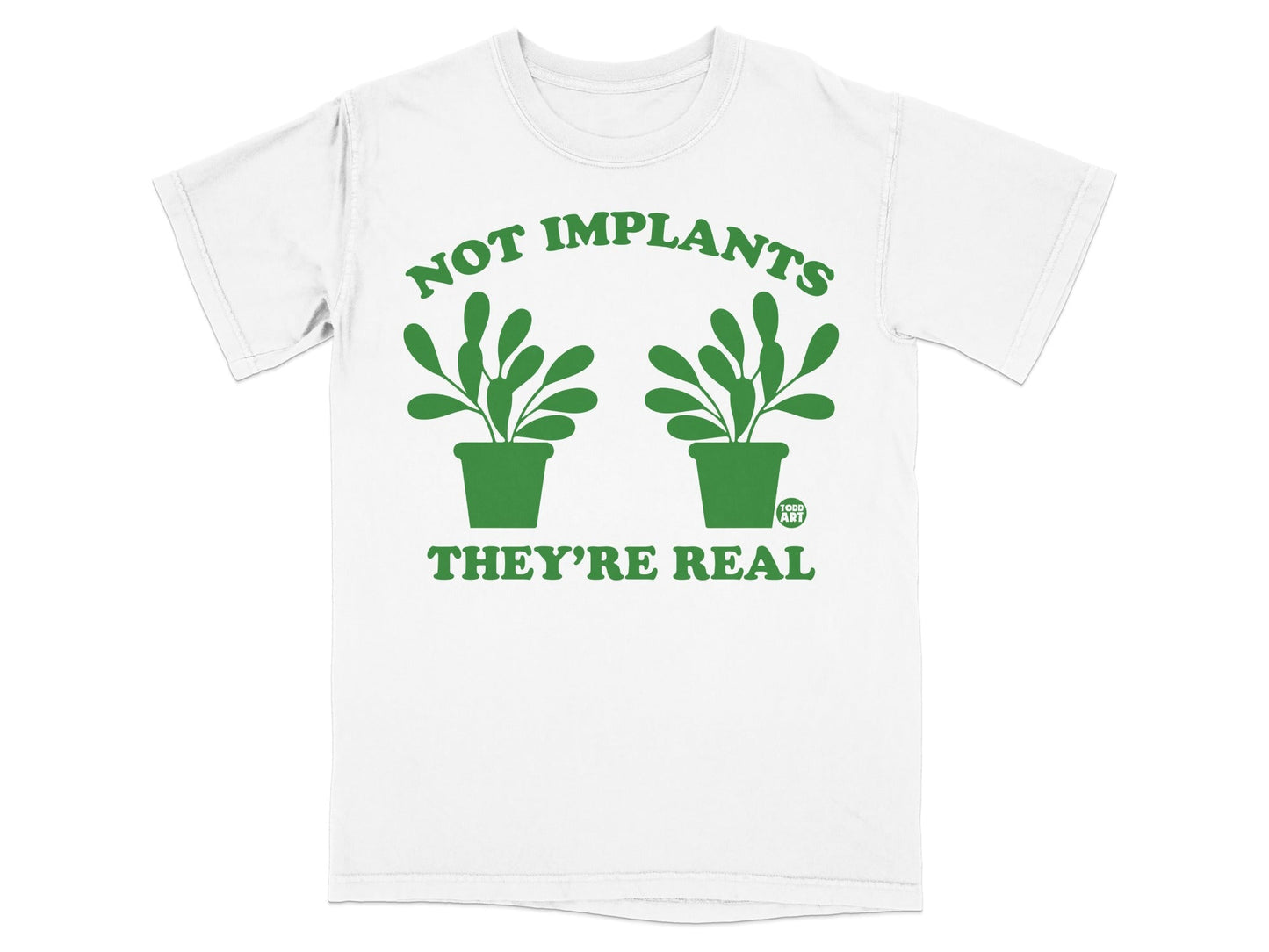 White t-shirt with green text "NOT IMPLANTS THEY'RE REAL" and two potted plants.