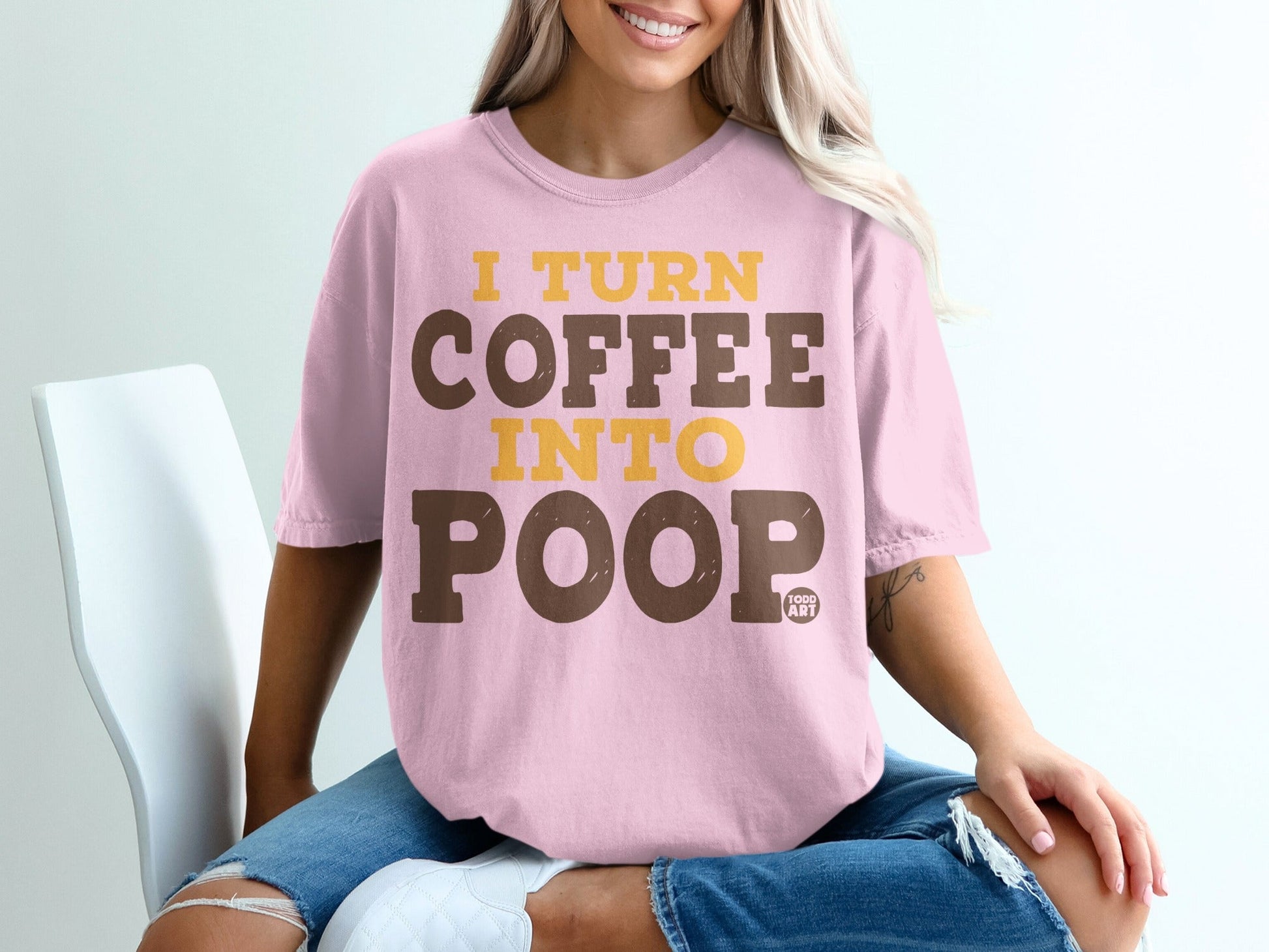 Pink t-shirt with text "I TURN COFFEE INTO POOP" in yellow and brown.