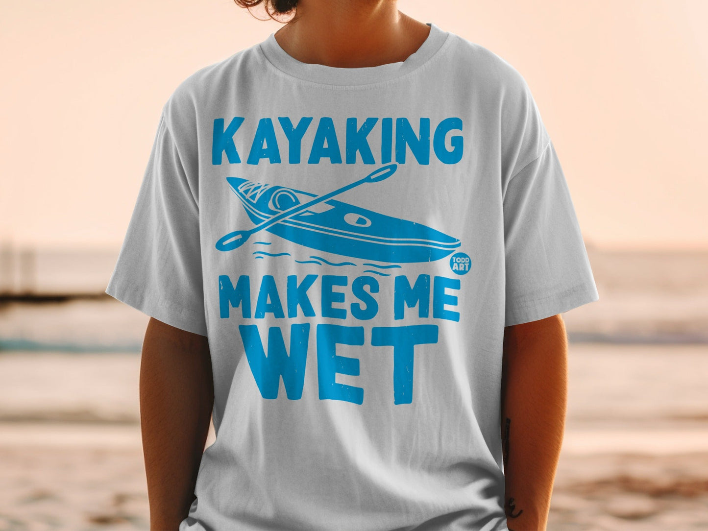 Blue t-shirt with white text and kayak graphic that reads "Kayaking Makes Me Wet."