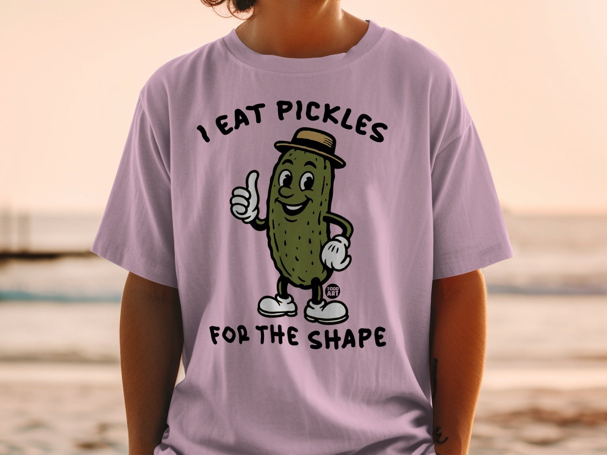 Shirt with cartoon pickle wearing a hat, giving a thumbs up.